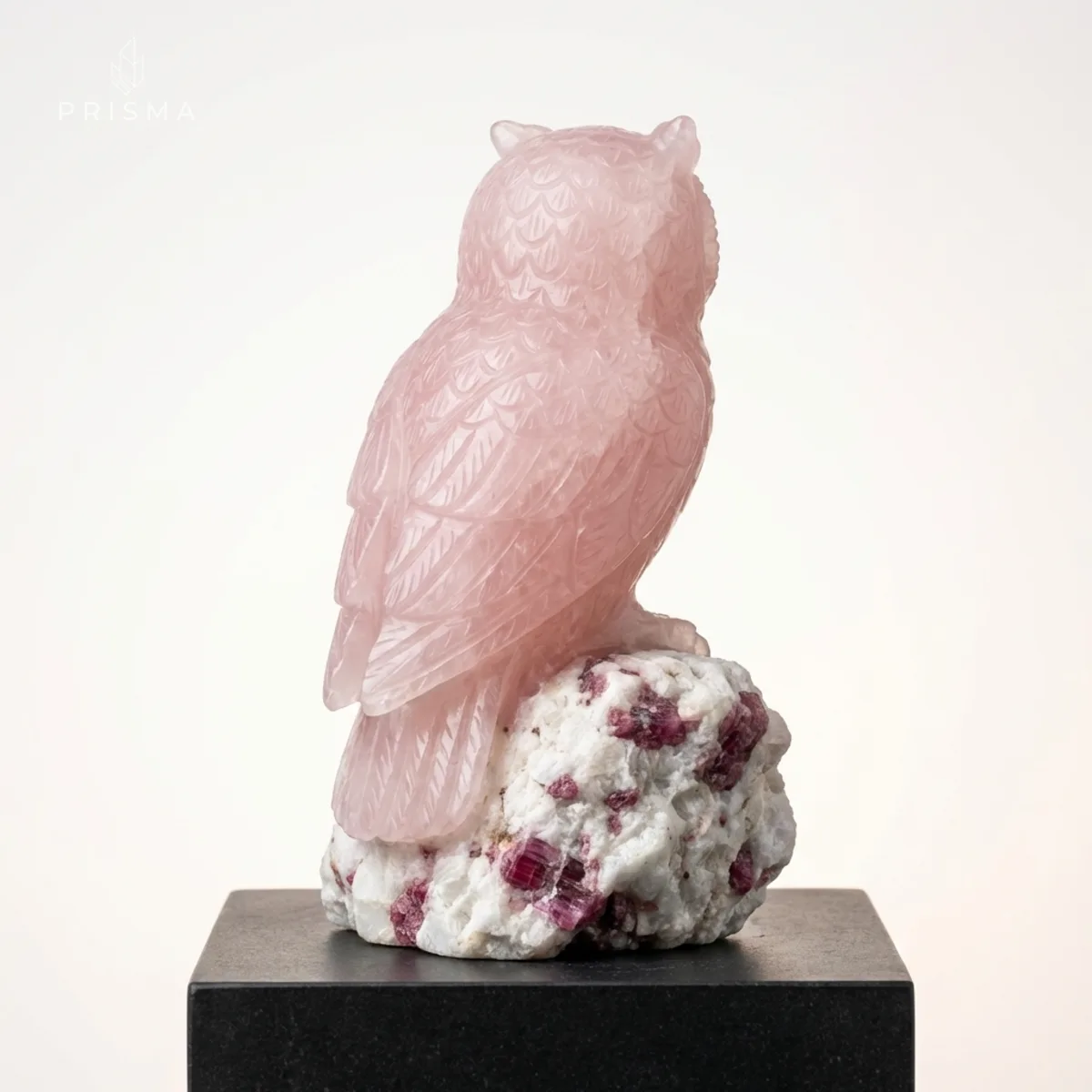Coruja de quartzo rosa vista posterior mostrando textura das penas e base de albita com turmalina