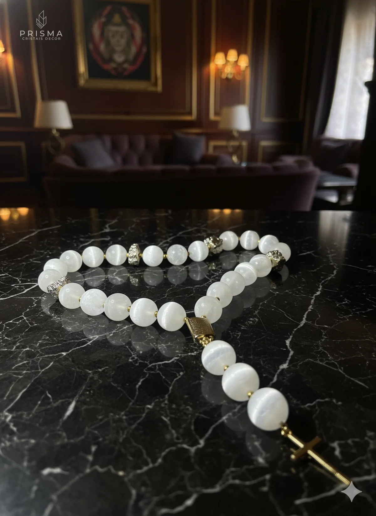 Terço de esferas de selenita branca sobre mármore escuro em ambiente de luxo — pedra da lua Prisma Cristais