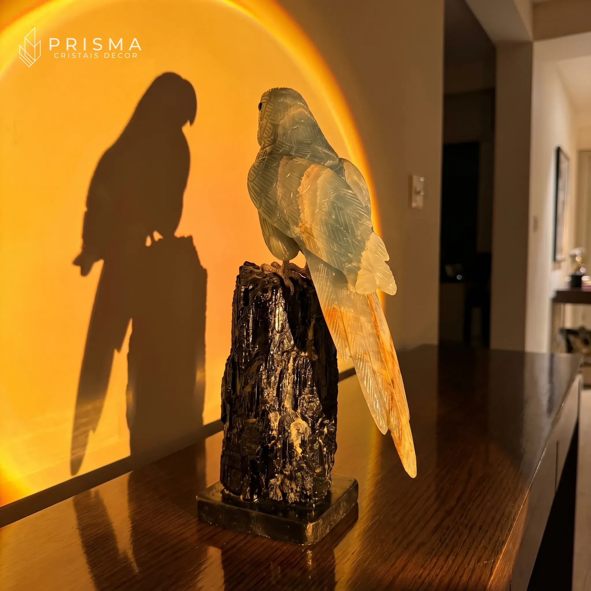 Arara Ônix Azul com luz dourada sunset em aparador de madeira escura — contraste entre o azul do ônix e a luz quente, residência de alto padrão