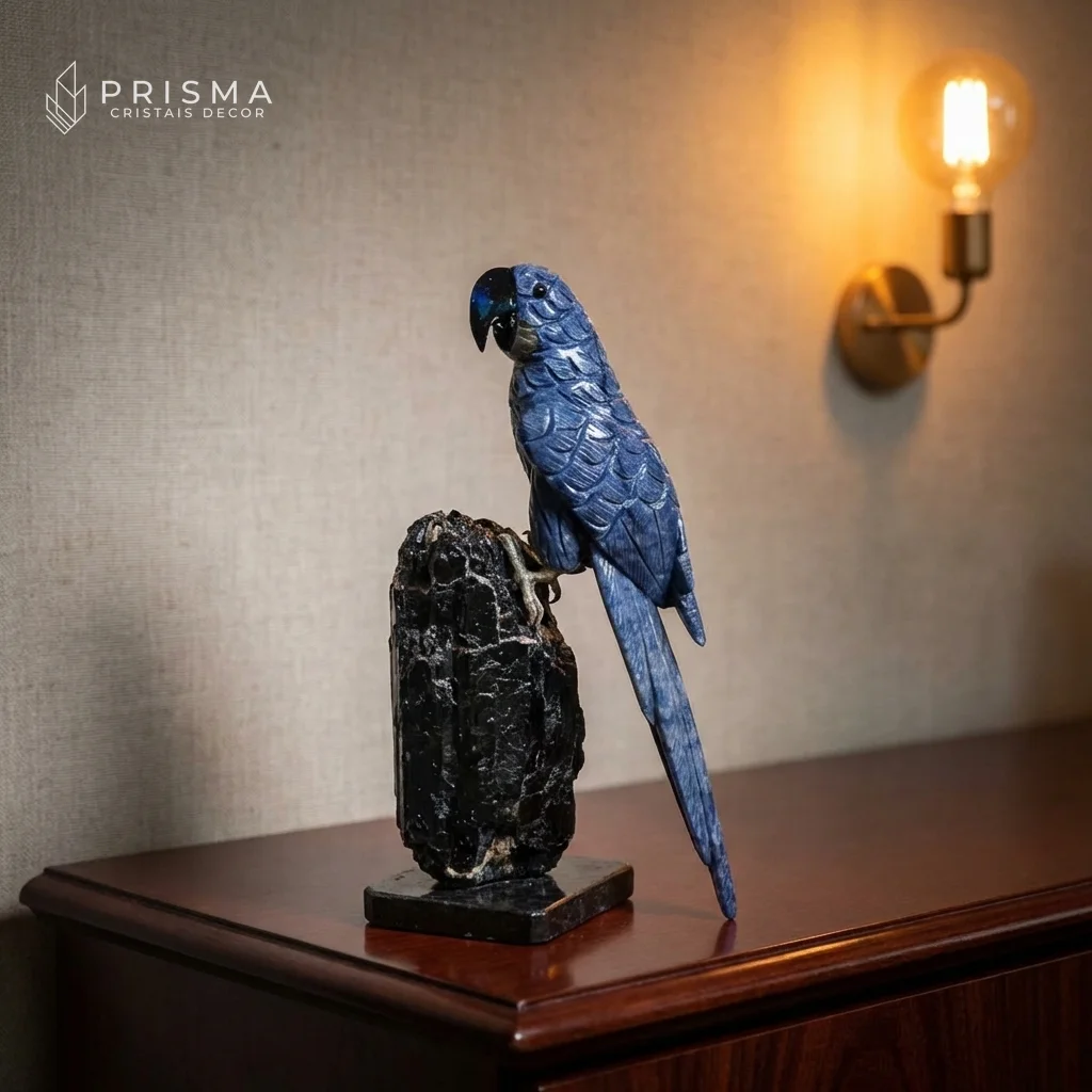 Arara em Quartzo Azul sobre console de madeira escura com luminária âmbar — escultura em cristal natural premium, decoração alto padrão Nova Lima MG