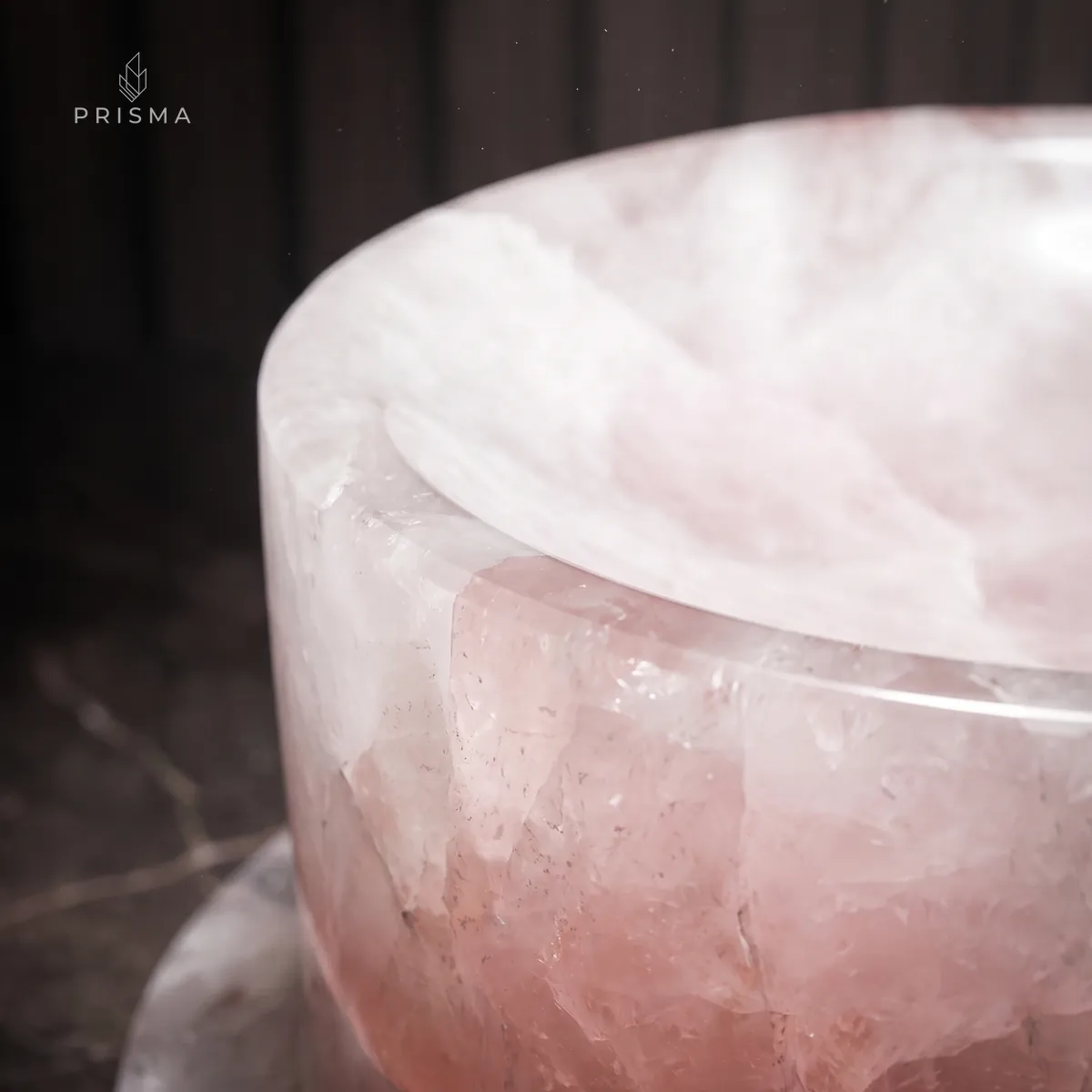 Borda arredondada do comedouro em quartzo rosa com a luz atravessando o cristal
