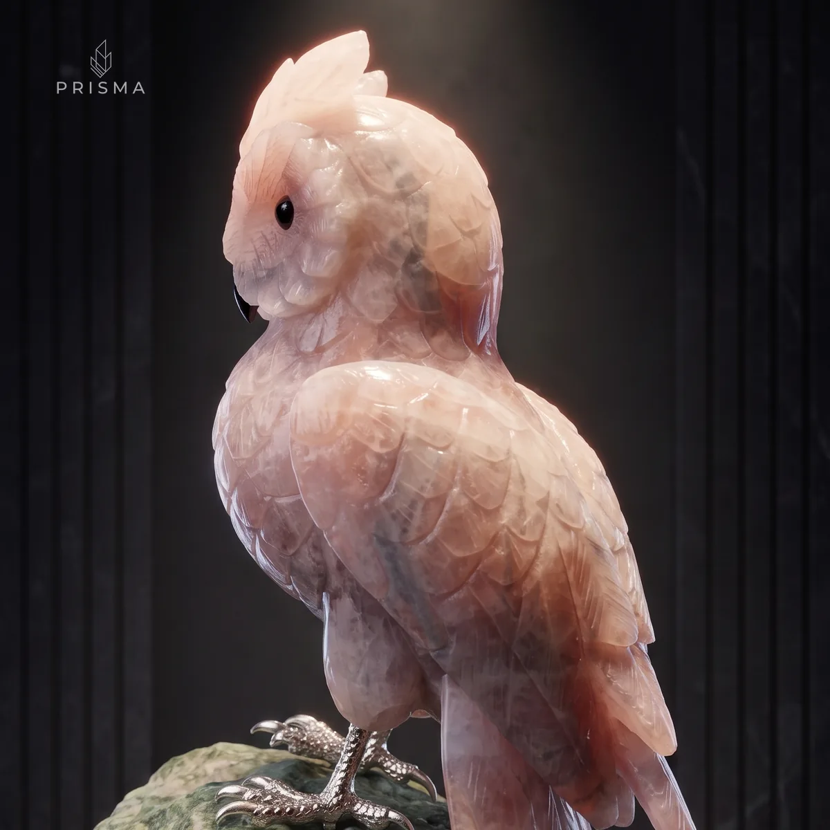 Perfil da escultura de coruja em quartzo rosa com a variação de cor nas asas e na cauda